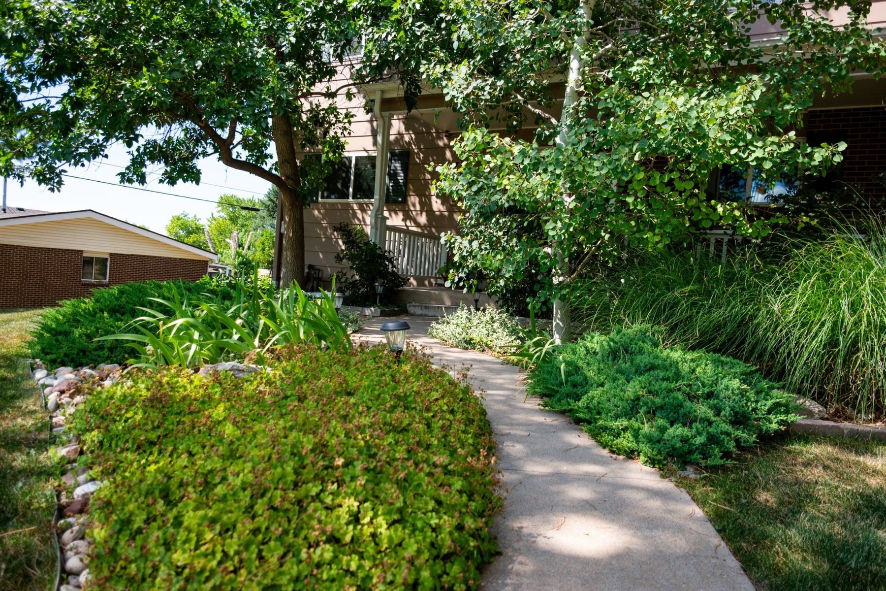 Landscaped front walkway leading toward a residential property