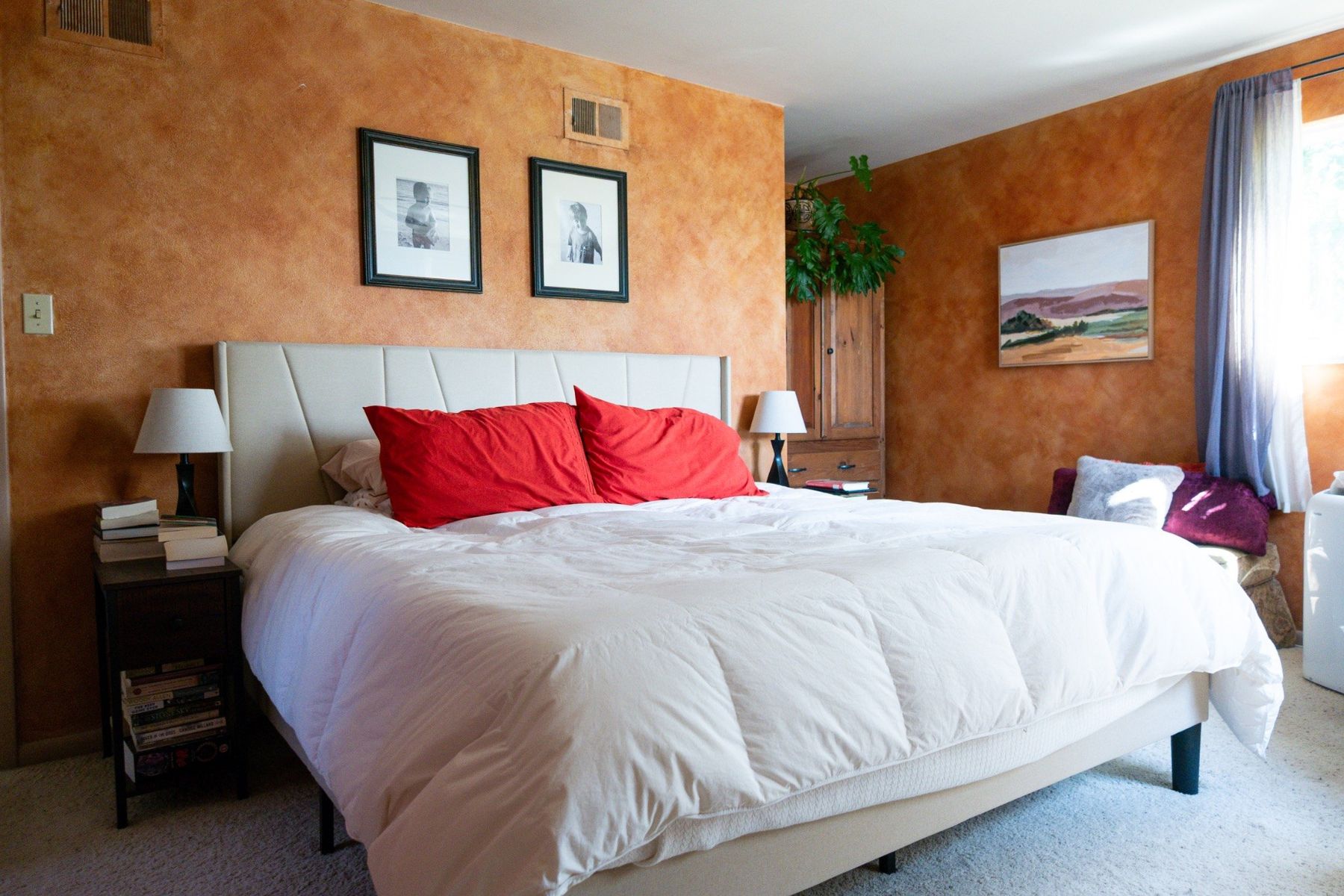 Primary bedroom with warm textured walls and white bedding