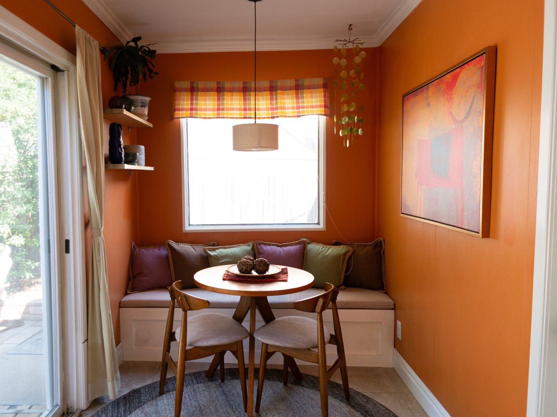 Orange breakfast nook with built-in bench and round dining table