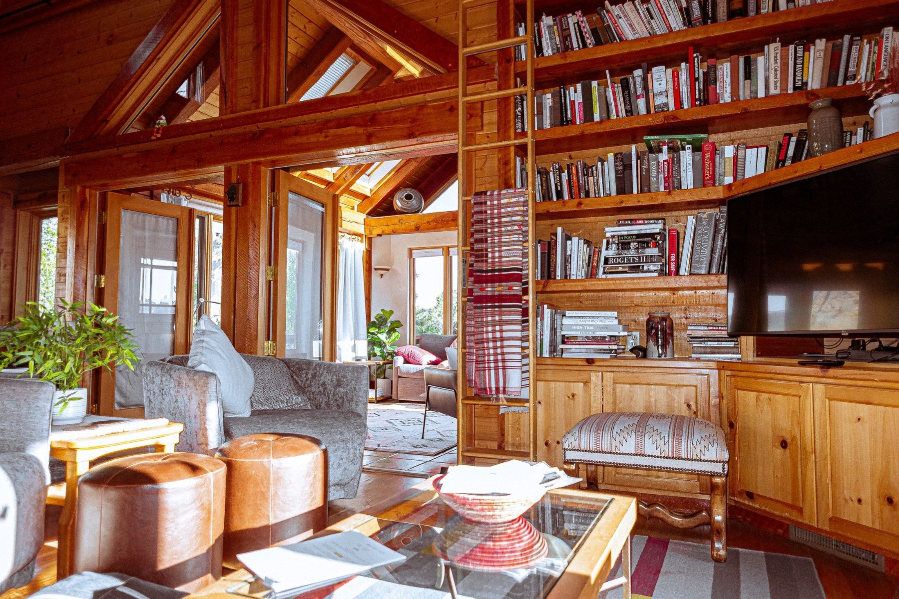 Wood-paneled living room with library wall and vaulted ceiling