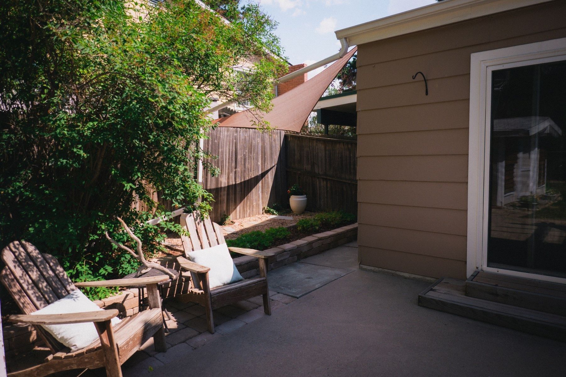 Private backyard seating area with mature landscaping